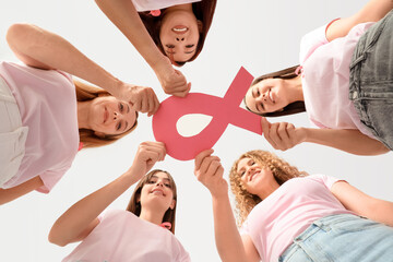 Beautiful women with pink ribbon on color background, bottom view. Breast cancer awareness concept - Powered by Adobe