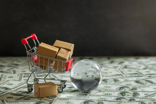 Global Business and Financial, Economic and Planning Concept. Shipping Boxes on shopping carts with Crystal globes in many currencies. global economy.World trade and delivery of purchases.