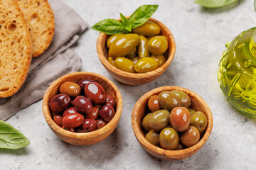An assortment of various olives presented in a bowl, showcasing different colors, textures, and flavors