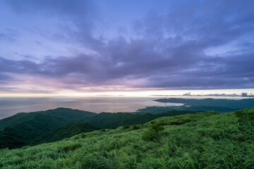 Fototapeta premium The summit offers panoramic views of the coastline and ocean, with soft, hazy skies overhead. Caoshan Radar Station, New Taipei City, Taiwan.