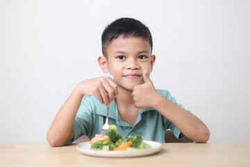 Nutrition healthy eating habits for kids concept. Children do not like to eat vegetables. Little cute boy refuses to eat healthy vegetables.