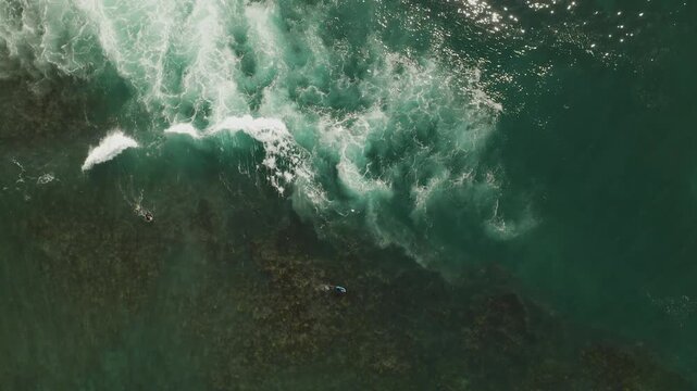 Aerial top down view of ocean waves over coral reef