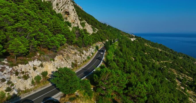 Drone shot of cars on road 8 on the coast of the Makarska riviera in Croatia