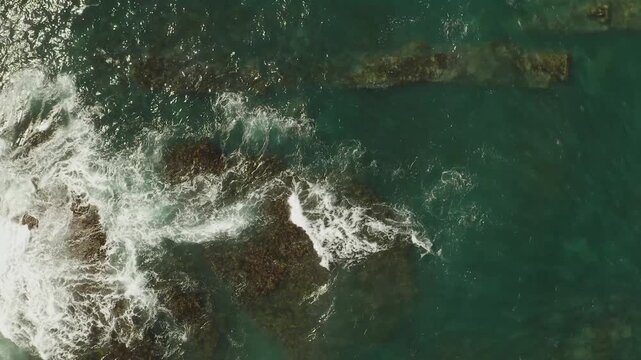 Aerial flying over coral reef and breaking waves in Sydney on scenic coastline in Australia.