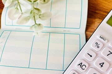 通帳と電卓、現金を銀行に預ける