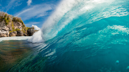 Barrel wave in ocean. Blue wave with sunlight. Panoramic view