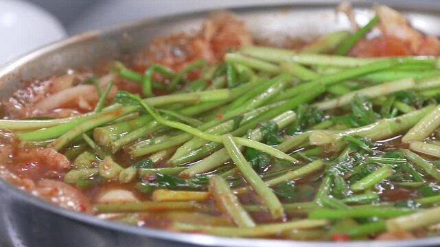 냄비에서 보글보글 끓는 전골에 들어간 신선한 미나리