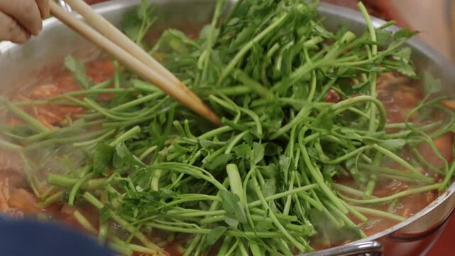 냄비에서 보글보글 끓는 전골에 들어가는 신선한 미나리