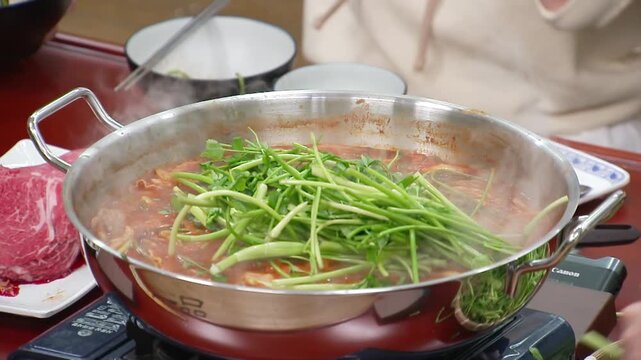 냄비에서 보글보글 끓는 전골에 들어가는 신선한 미나리
