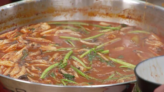 신선한 미나리와 고기가 들어간 전골을 젓가락으로 덜어먹는 모습