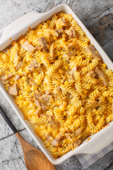 Tuna Mornay Creamy Tuna Casserole Pasta Bake closeup on the baking dish on the table. Vertical top view from above