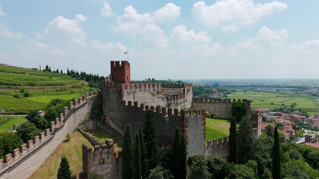 Imposing fortress of Soave Castle on a hill in Northern Italy, sunny daytime aerial