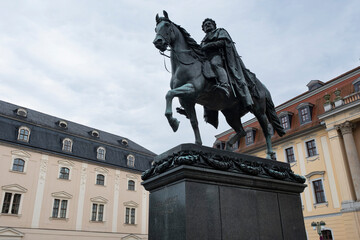 Statue of Carl August, Grand Duke of Saxe-Weimar-Eisenach on the Democracy Square in Weimar. Behind it the Anna Amalia Library and Franz Liszt University of Music. Weimar, Germany, July 22 2024
