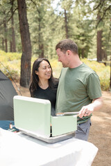 Couple grilling in the woods while camping