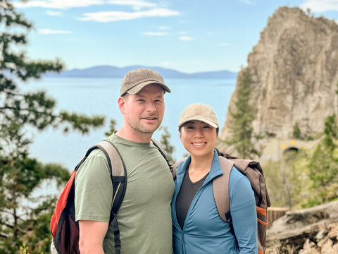 Couple hikers smiling at camera with mountain behind