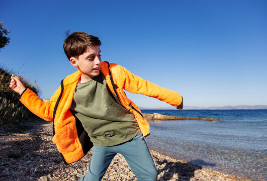 Boy skipping stones by the sea