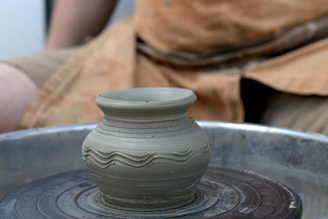 Creating a clay vase on the potter's wheel. Handmade concept.