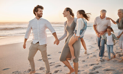 Parents, grandparents and holding hands with children at beach, sunset or happy with bonding on...