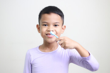 child Asia kid boy brushing teeth isolated on white backgroud.