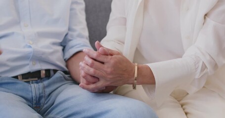 Close up shot of senior couple joining hands. Loving mature wife and husband sitting together, supporting and comforting each other. Family relationships unity, support, partnership and companionship.