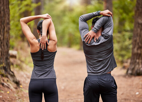 Back, fitness and stretching with couple in forest for start of marathon, training or workout. Exercise, health and warm up with athlete or runner people in nature for cardio preparation together