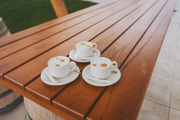 cup of black coffee on the wooden table outdoor cafe. three cups of coffee on the table. 