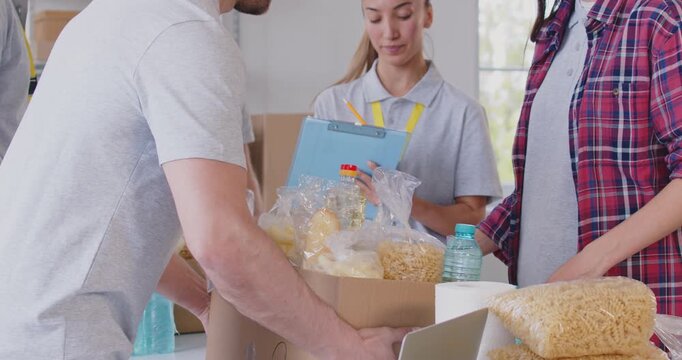 Food bank box giving help, volunteer group working in charitable meal foundation making donation to needy. Charity separating donations stuff, basic need provisions, free meal for people in need, care