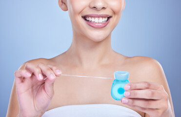 Dental floss, smile or hands of woman in studio on blue background for cleaning or oral hygiene. String closeup, dentistry or model with product for tooth care to prevent cavity, decay or gum disease