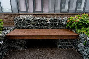 A beautifully crafted wooden bench nestled beside a weathered stone wall creates an inviting outdoor space that is truly ideal for relaxation and deep contemplation beneath the open sky