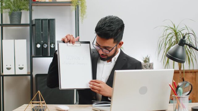 Indian businessman freelancer making online presentation video laptop call education lessons for remote study student classes at office workplace. Male Hindu in suit demonstrates graphic analytics