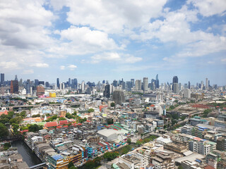 High angle view from the top of a building, seeing the city below, with a small river and road. Houses and skyscrapers serve as a backdrop..Photography.