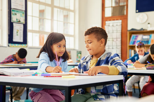 Schoolgirl helping classmate in difficulty during lesson