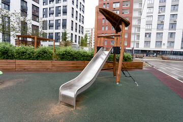 A contemporary playground slide designed for urban environments, featuring safety enhancements for...