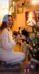 Girl with pajamas in the living room with her Border Collie dog. Happy moment in the house.