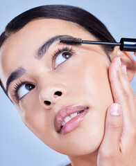 Woman, thinking and mascara brush in studio for eyelash treatment, application and blue background. Female person, cosmetic tool and skincare for makeup product, cosmetics and hydration for lashes