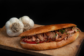 Shawarma and garlic on the wooden desk on black background