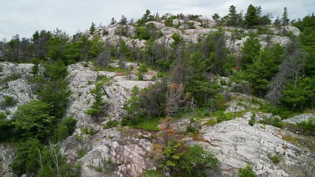 Aerial ascent up forested rocky mountain, Manitoulin Islands, Ontario, Canada