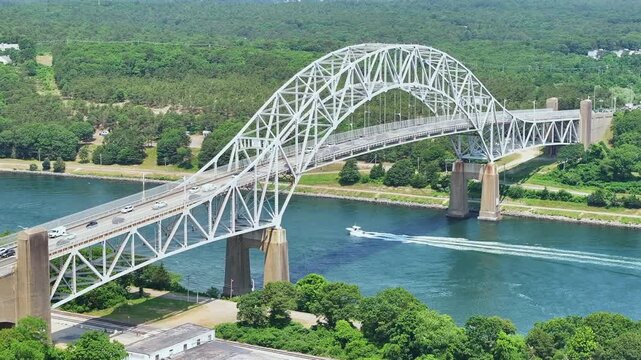 Cape cod sagamore bridge over blue water with lush green surroundings, aerial view