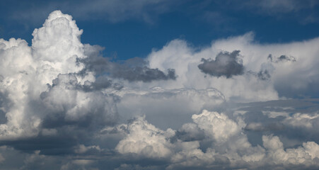 View of white fluffy clouds over blue sky.