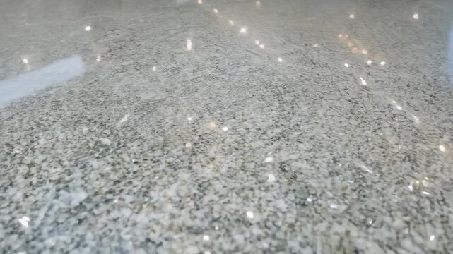 Smooth and glossy surface of a granite countertop in a well-lit kitchen