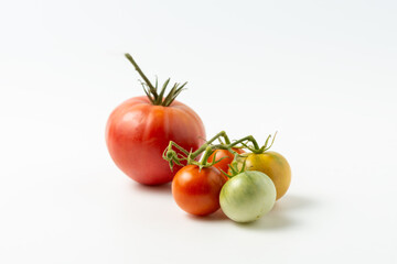 Ripe and green natural tomatoes on a white background. Close up.