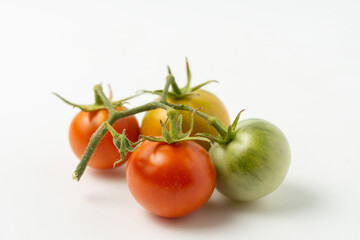 Ripe and green natural tomatoes on a white background. Close up.