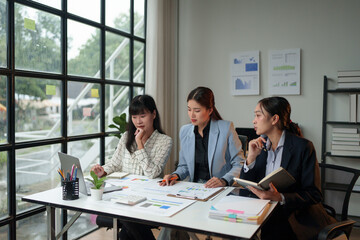 Group of businesswomen meeting in the office Calculate your company's tax and investment income. Strategic planning and brainstorming of colleagues, report, analysis, plan, graph.