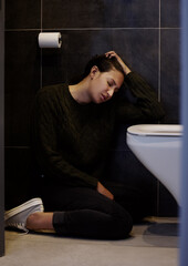 Bathroom, sick and woman with nausea, floor and symptoms of food poisoning, pain and tired of...