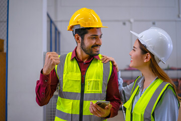 Blue collar workers are using smart phone at warehouse.