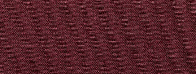 Texture dark red background from textile material with wicker pattern, macro. Structure of vintage wine fabric cloth,