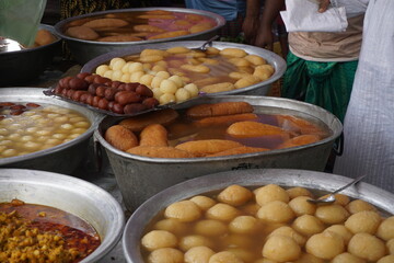 Popular Bangladeshi dessert Gulab Jamun with sugar syrup, Traditional Bangladeshi sweet called rasgulla or rasgoola is being sold at a market, Gulab jamun and rasgulla are displayed together