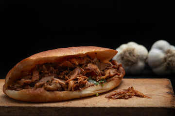 Shawarma and garlic on the wooden desk on black background
