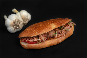 Shawarma and garlic on the wooden desk on black background