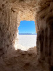 View of the salt marsh through the window of a house made of salt blocks. Salinas Grandes, Argentina